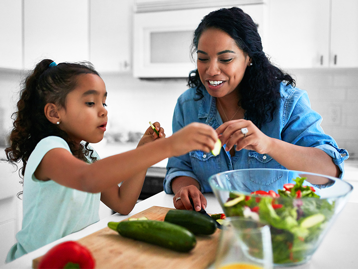 Mother and daughter preparing a salad