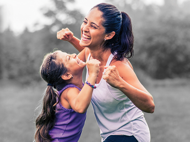 Mother and daughter dancing outside