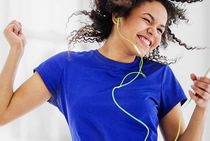 Woman wearing earphones and dancing