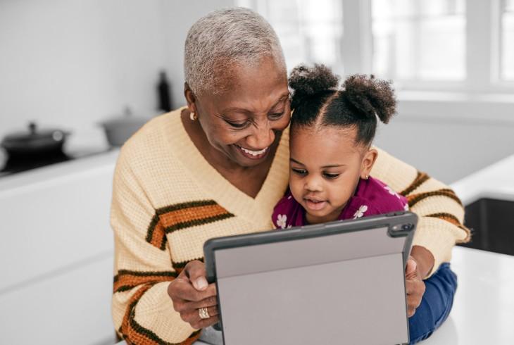 Grandmother and granddaughter viewing a tablet 